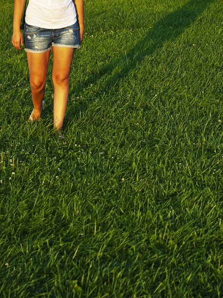 Meisje lopen in het gras — Stockfoto