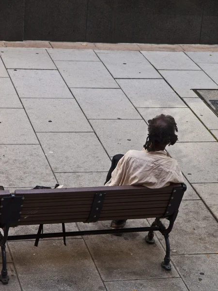 Beggar sitted on a bench — Stock Photo, Image