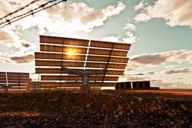 Dramatic View of Solar Panels at Sunset clipart