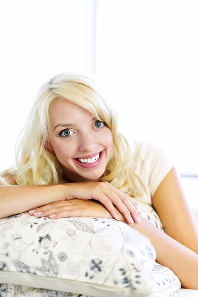 Mulher feliz no sofá em casa — Fotografia de Stock