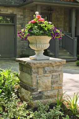 Stone planter in front of house clipart