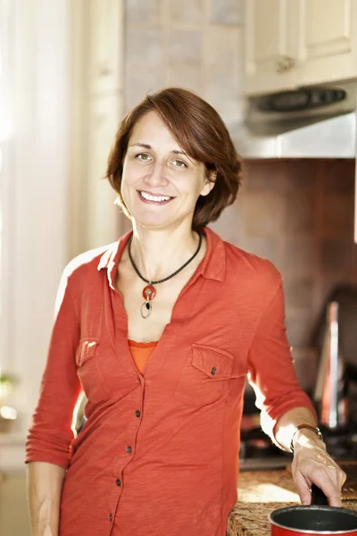 Glad kvinna i köket hemma — Stockfoto