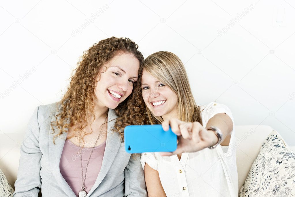 Two women taking photo with phone