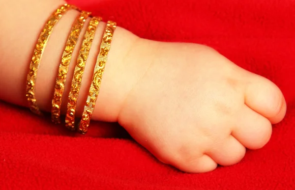 Mão de bebê com ouro — Fotografia de Stock