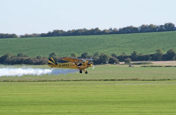 Piper Cub plane with smoke — Stock Photo, Image