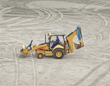 An excavator truck parked on the sand clipart