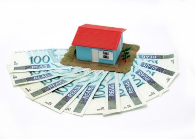 House with money over white background - mortgaging concept clipart