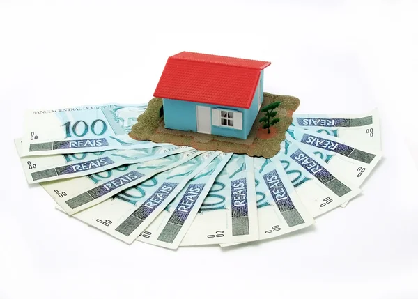 Ház pénz felett fehér háttér - jelzáloggal koncepció Stock Kép