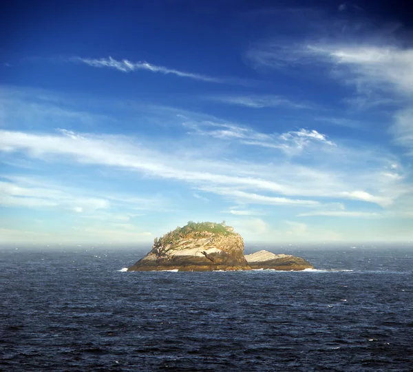 Самотній острів на морі під красивим блакитним небом і хмарами — стокове фото