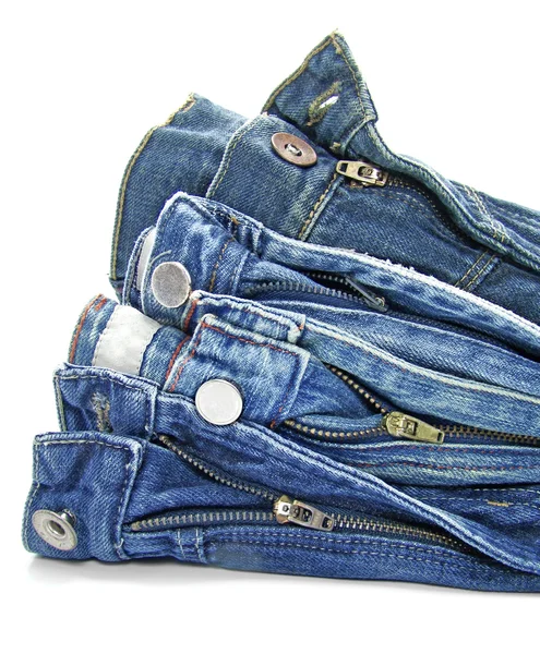 Hromadu modré džíny nad bílým pozadím — Stock fotografie