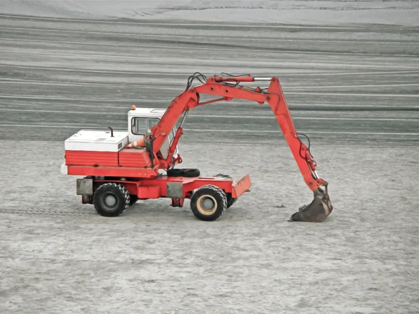 Red excavator tractor waiting to clean the beach sand — Stock Photo, Image