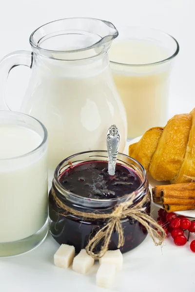 Verse melk in de kruik en cup en croissant — Stockfoto