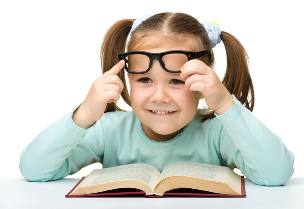 可爱的小女孩看书戴眼镜 — 图库照片