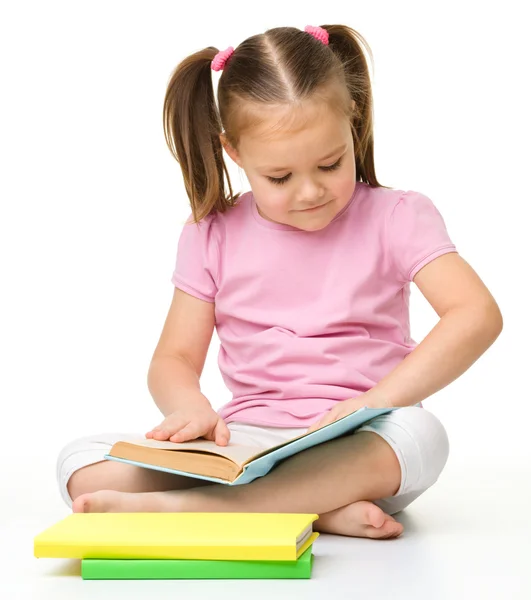Søt liten jente leser en bok. – stockfoto