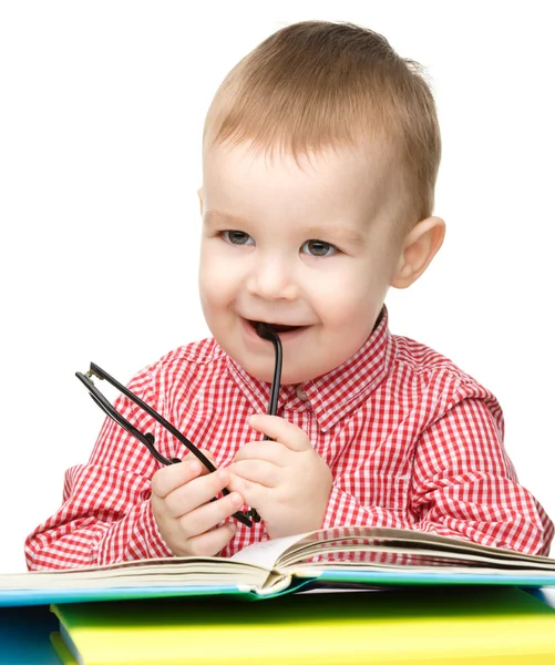 Niño pequeño juega con el libro y las gafas —  Fotos de Stock