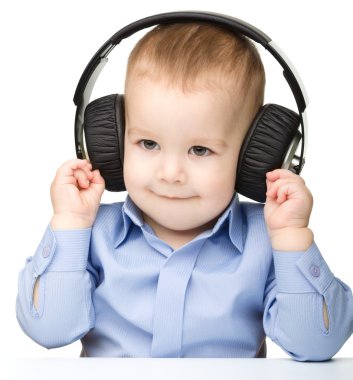 sevimli küçük çocuk kulaklık kullanarak müzik keyfi