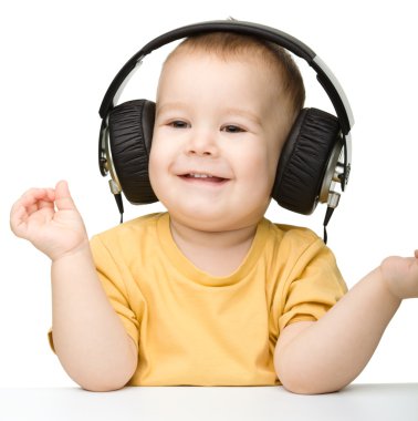 sevimli küçük çocuk kulaklık kullanarak müzik keyfi