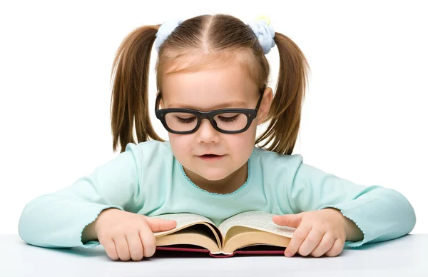 Aranyos kislány elolvassa a könyvet, szemüveg — Stock Fotó