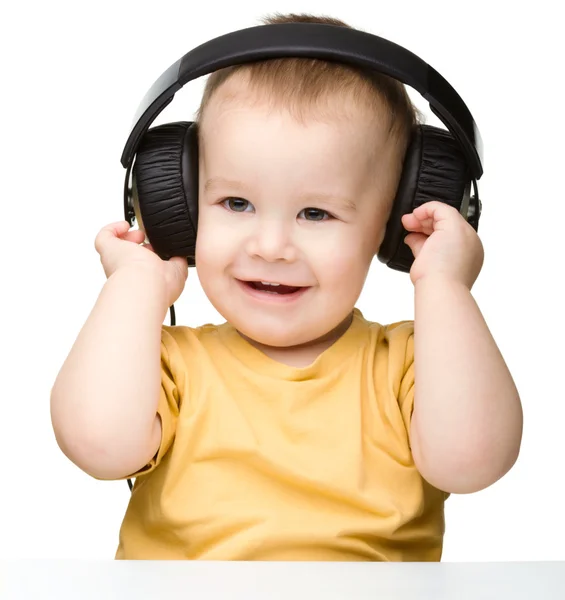 Lindo niño disfrutando de la música usando auriculares —  Fotos de Stock