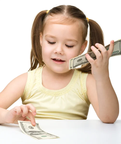 Χαρούμενα το χαριτωμένο κοριτσάκι μετρά δολάρια — Φωτογραφία Αρχείου