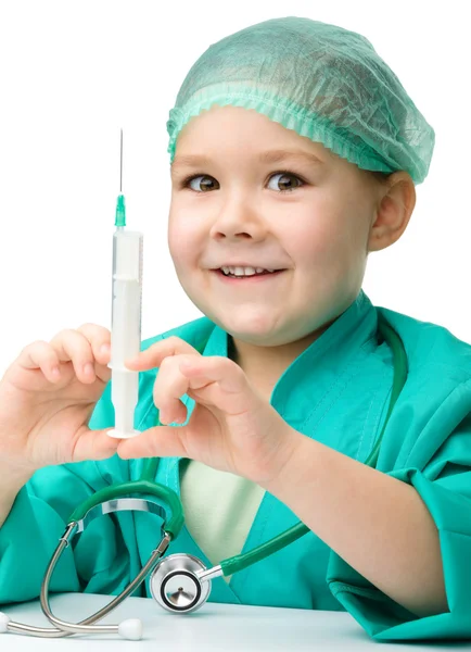 Милая маленькая девочка играет в доктора со шприцем — стоковое фото