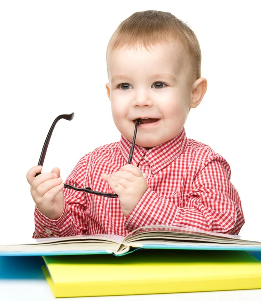 Liten barn lek med bok och glasögon — Stockfoto