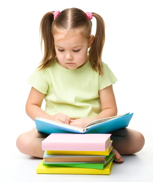 Χαριτωμένο κοριτσάκι διαβάζει ένα βιβλίο — Φωτογραφία Αρχείου
