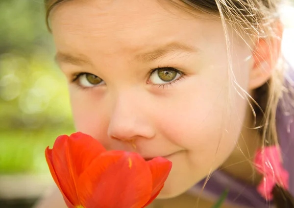 Porträt eines niedlichen kleinen Mädchens, das Blumen riecht — Stockfoto
