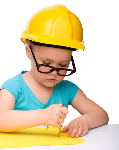 Little girl is playing while wearing hard hat — Stock Photo, Image