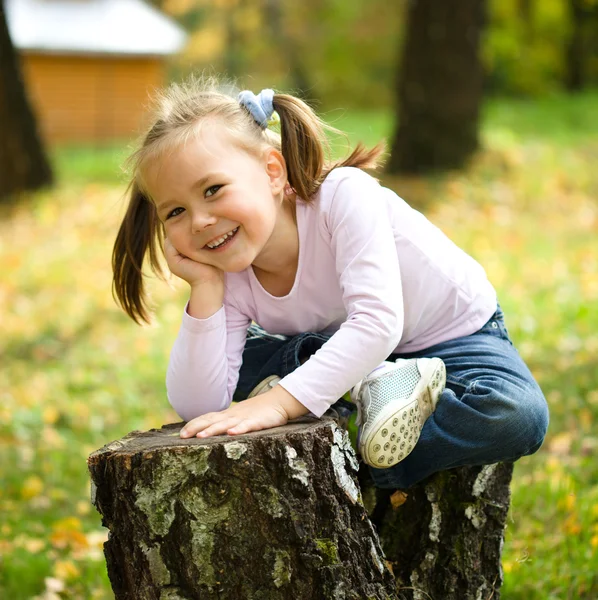 Little girl is playing in autumn park — Stock Photo, Image