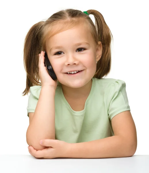 Милая маленькая девочка разговаривает по мобильному телефону — стоковое фото