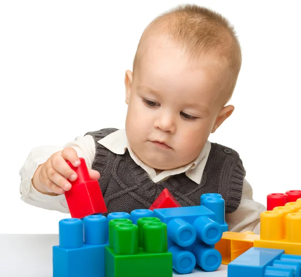 Little boy plays with building bricks Stock Photo