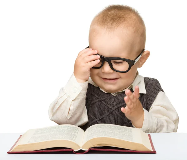 Niño pequeño juega con el libro y las gafas — Foto de Stock