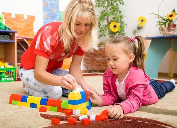 Nauczyciel i dzieci grają z cegły — Zdjęcie stockowe