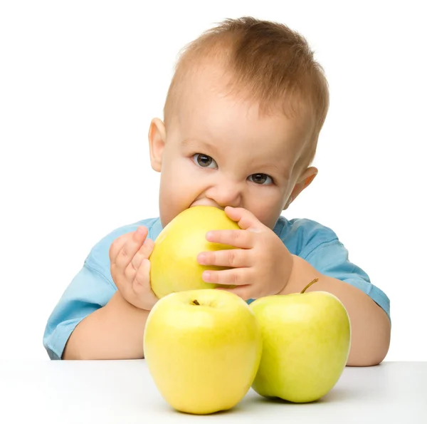 Malý chlapec kousání žluté jablko — Stock fotografie