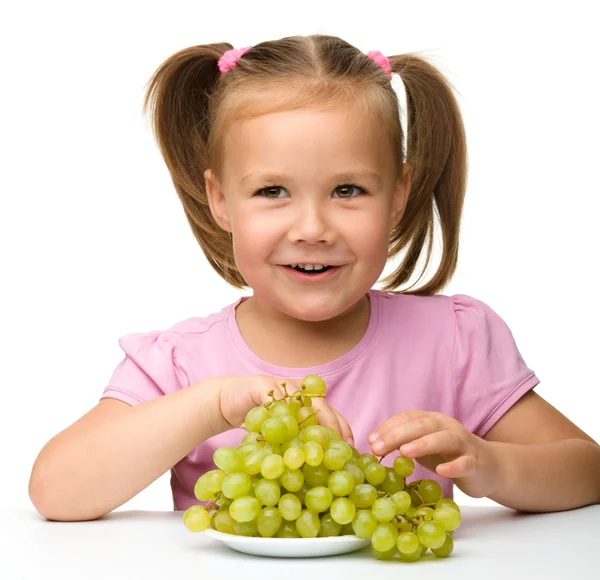 La bambina sta mangiando uva. — Foto Stock