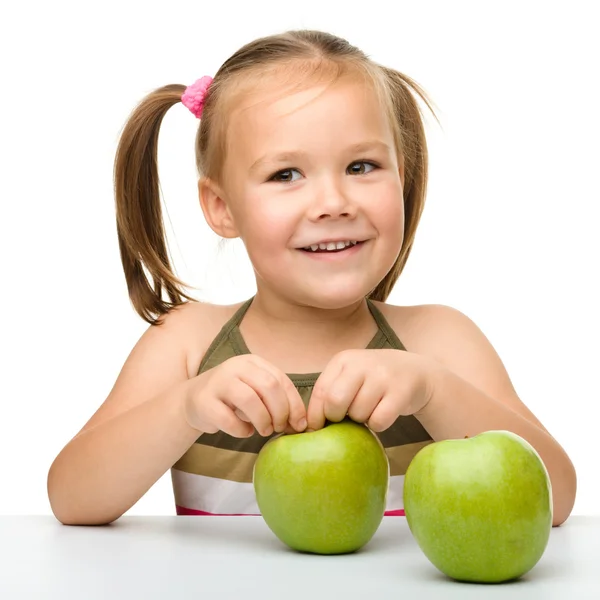 Kleines Mädchen mit zwei grünen Äpfeln — Stockfoto