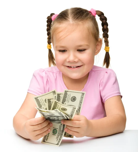 Söt liten flicka räknar dollar — Stockfoto
