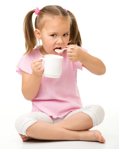Carina bambina sta mangiando yogurt — Foto Stock