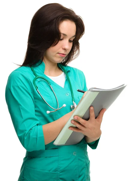 Młoda atrakcyjna kobieta lekarz pisze — Zdjęcie stockowe