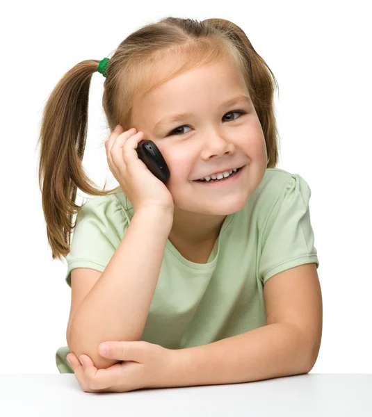 Милая маленькая девочка разговаривает по мобильному телефону — стоковое фото