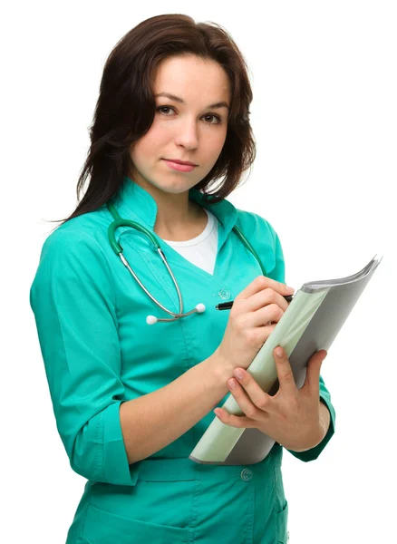 Młoda atrakcyjna kobieta lekarz pisze — Zdjęcie stockowe