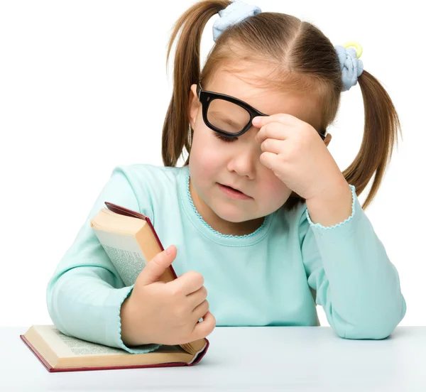 Kleines Mädchen liest mit Brille ein Buch — Stockfoto