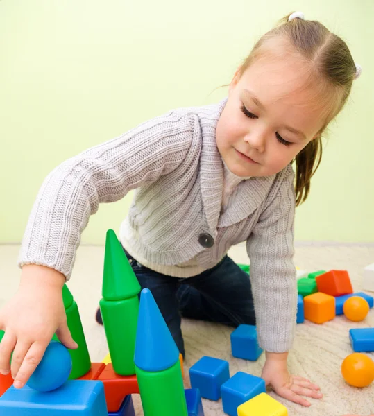 Malá holčička se hraje s hračkami v mateřské školce — Stock fotografie