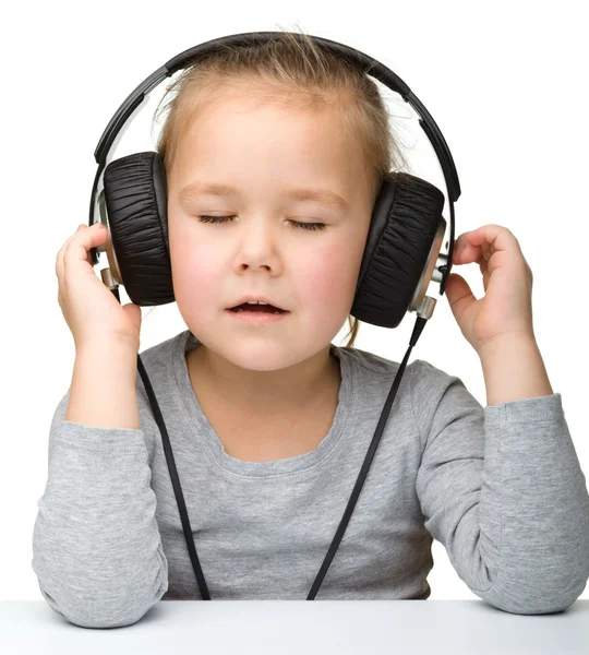 Gadis manis menikmati musik menggunakan headphone — Stok Foto