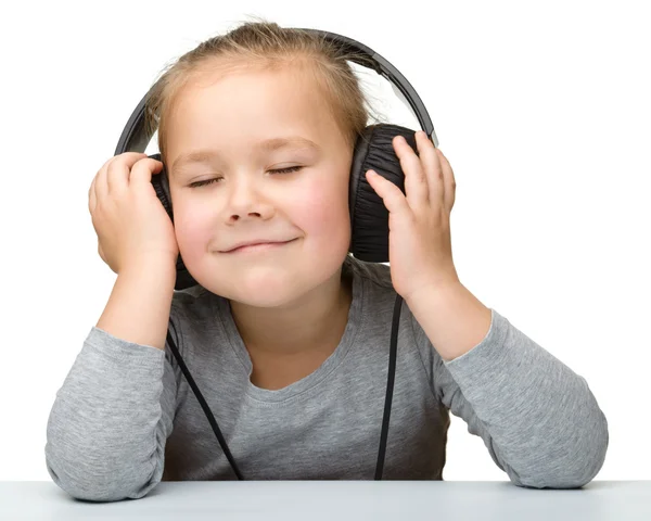 Leuk meisje genieten van muziek met behulp van de hoofdtelefoon — Stockfoto