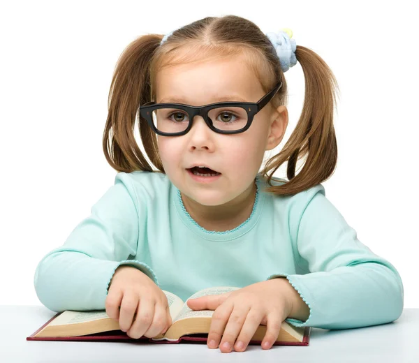 Holčička čte knihu brýlemi — Stock fotografie