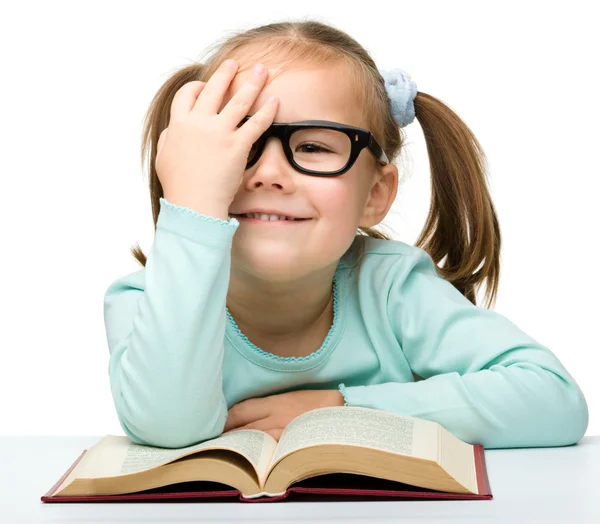 Kleines Mädchen liest mit Brille ein Buch — Stockfoto