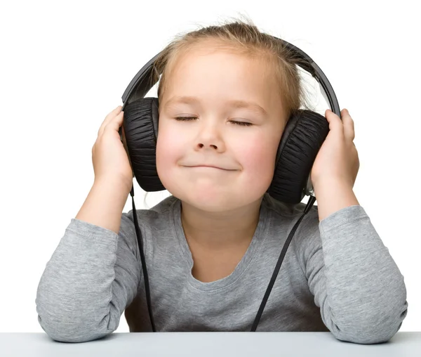 Linda chica disfrutando de la música usando auriculares —  Fotos de Stock