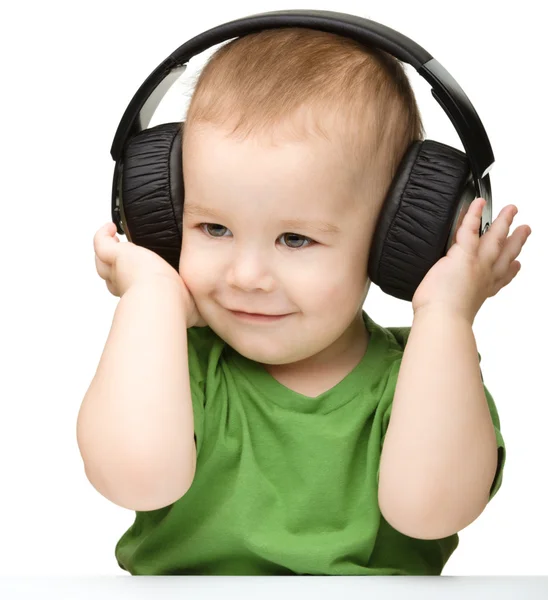 Lindo chico disfrutando de la música usando auriculares — Foto de Stock